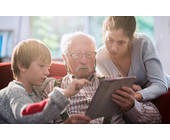 Opa mit seinen Enkeln am Tablet