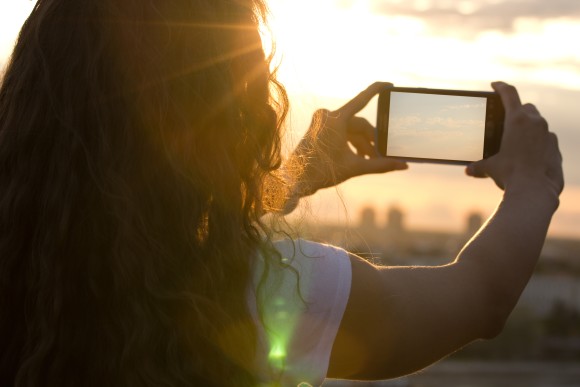 Frau fotografiert mit ihrem Smartphone 