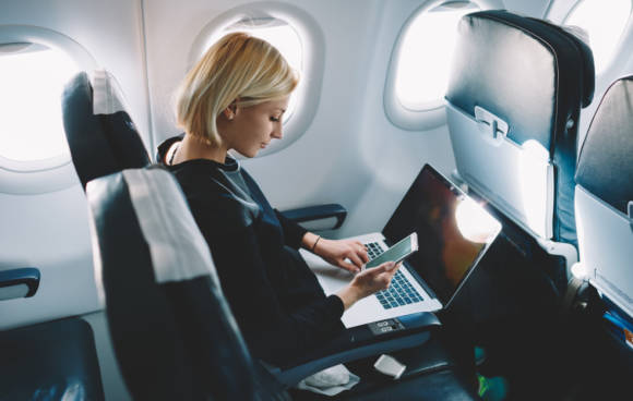 Frau am Notebook während Flugreise 
