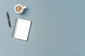 Kaffee, Stift, Block auf einem Schreibtisch 