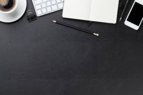 Stift, Block, Kaffee, Handy auf einem Schreibtisch 