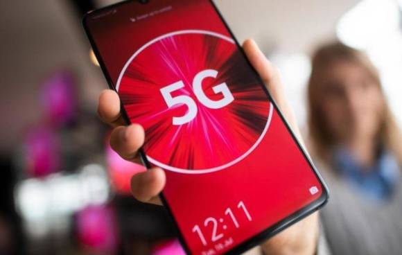 Eine Vodafone-Mitarbeiterin hält ein 5G-Smartphone in der Hand. 