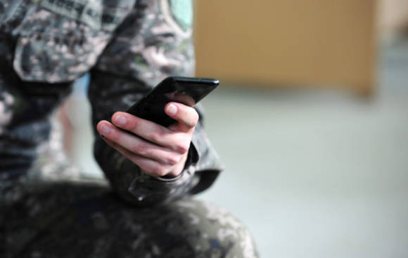 Soldat mit Smartphone in der Hand 