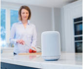 Frau in der Küche mit einem smarten Speaker