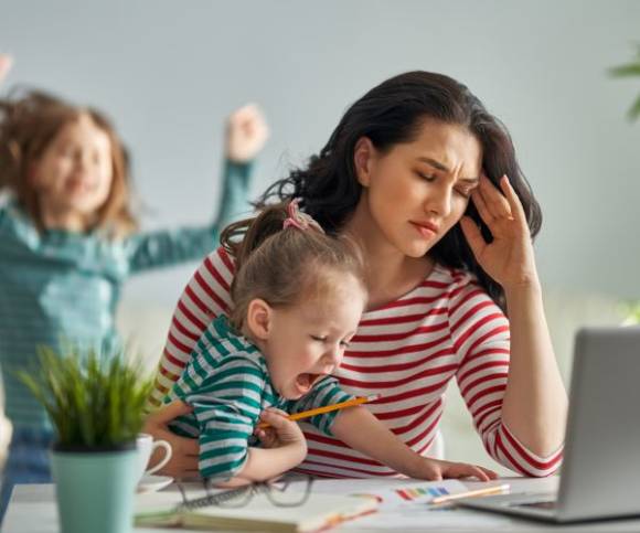 Junge Frau mit Kindern im Home Office 