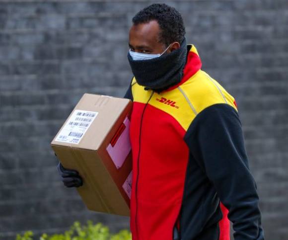 DHL-Bote mit Corona-Maske 