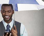 Mann mit Regenschirm und Smartphone