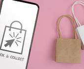 Click&Collect Symbol auf Smartphone und Einkaufstüten