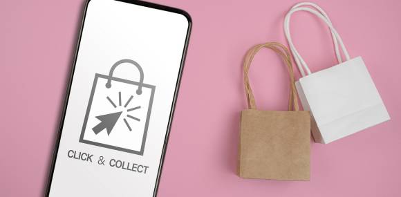 Click&Collect Symbol auf Smartphone und Einkaufstüten 