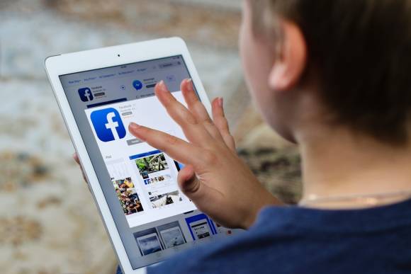 Junge nutzt Facebook auf dem Tablet 