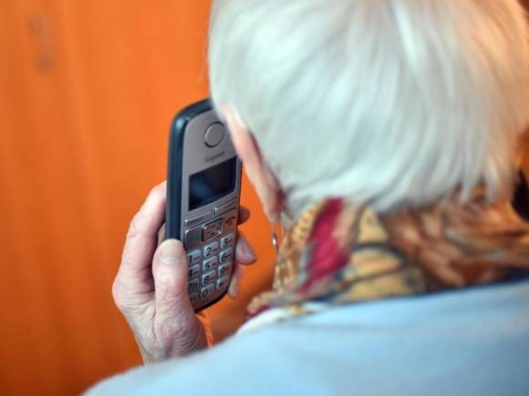 Senior mit Festnetztelefon 