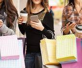 Junge Frauen mit Einkaufstüten und Smartphones