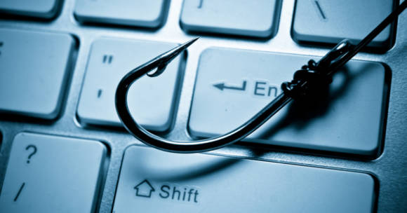 Symbolbild eines Angelruten-Hakens auf einer Notebook-Tastatur 