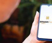 Person mit Handy mit Amazon Flex-Logo