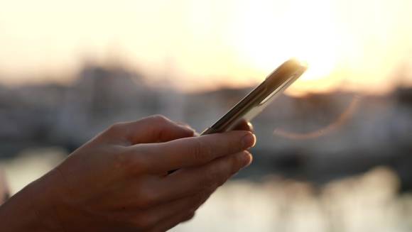 Smartphone mit Hafen im Hintergrund 