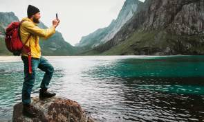 Mann mit Smartphone in der Wildnis 