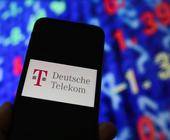 Telekom-Logo auf einem Smartphone vor einer Tafel mit Aktienkursen