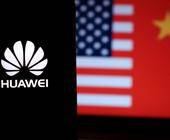 Huawei-Logo vor chinesischer und US-amerikanischer Flagge