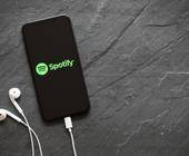 Smartphone mit kopfhörern und Spotify-App