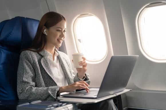 Frau mit Laptop im Flugzeug 