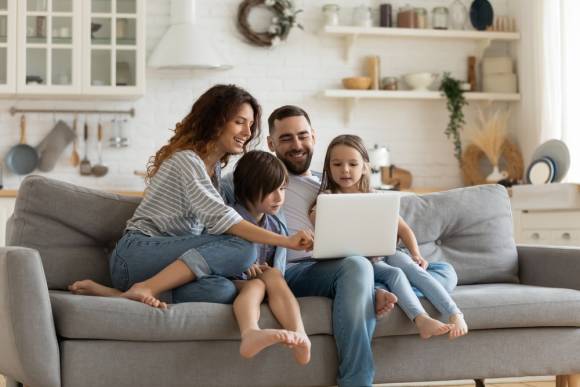 Familie sitzt auf dem Sofa und surft im Internet 