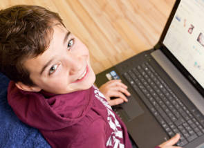 Junge sitzt vor einem Laptop 
