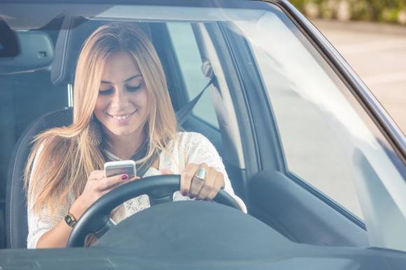 Autofahrerin mit Handy im Auto 