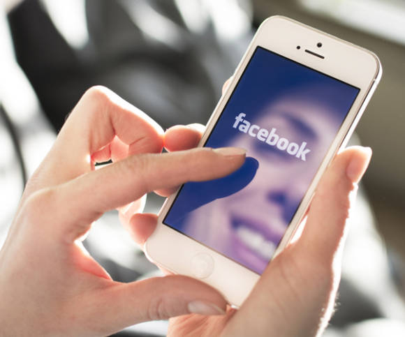 Frau surft auf Facebook am Smartphone 