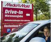 Frau im Auto vor Mediamarkt