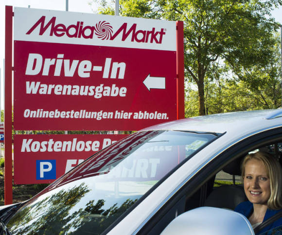 Frau im Auto vor Mediamarkt 