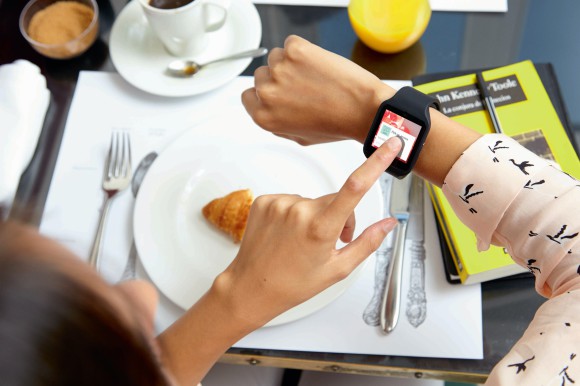 Person tippt auf eine schwarze Sony Smartwatch 