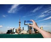 Die Skyline einer Stadt wird mit einem Smartphone fotografiert