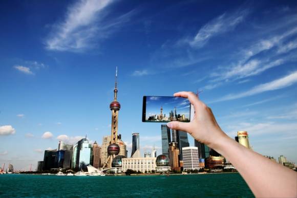 Die Skyline einer Stadt wird mit einem Smartphone fotografiert 