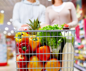 Ein Paar schiebt einen Einkaufswagen durch den Supermarkt