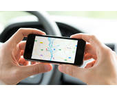 Autofahrer mit Handy und Maps