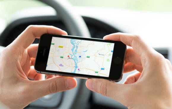 Autofahrer mit Handy und Maps 