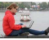 Frau surft mit Laptop an der Binnenalster