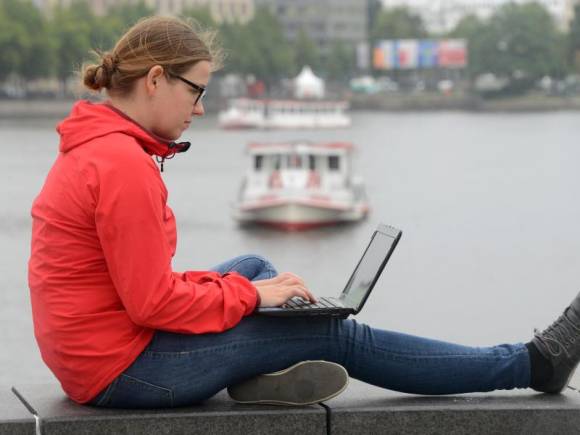 Frau surft mit Laptop an der Binnenalster 