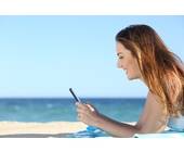 Frau mit Smartphone am Strand