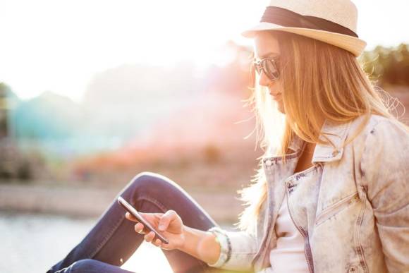 Frau mit Hut und Smartphone 