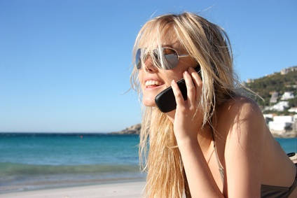 Frau mit Handy am Strand 