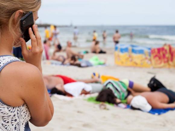 Frau telefoniert am Strand 