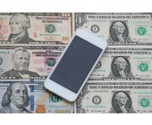 Smartphone liegt auf Dollar-Noten