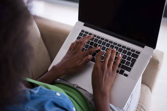 Junge Frau surft mit Laptop 